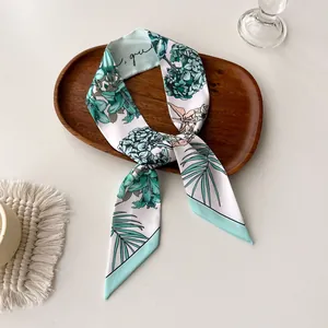 Detail of floral skinny scarf with green hydrangea print on a rustic wooden tray