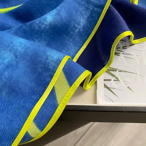 Close-up of herringbone weave pattern on blue and yellow linen-cotton sun-protective scarf