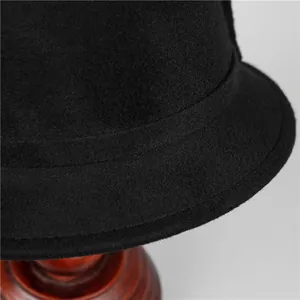Detailed close-up of premium black wool felt cloche hat showing fine brim stitching
