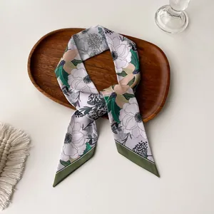 Detailed view of floral silk neck scarf in lavender with white flower pattern and green border