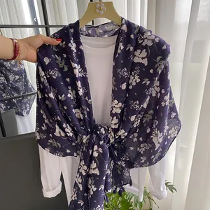 Detail of purple cotton linen scarf with white floral print and elegant fringe edges