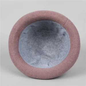 Detail of warm pink knit hat showing thick grey fleece lining and premium craftsmanship
