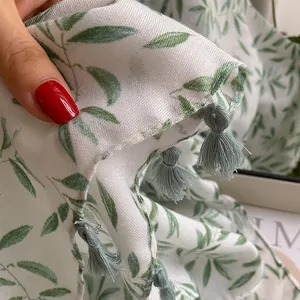 Elegant white cotton linen scarf with green leaf print and blue fringe tassels for women