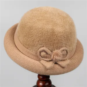 Close-up of knit winter cloche hat with fuzzy texture, bow decoration and fur pompom