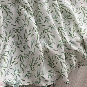 Elegant cotton-linen scarf featuring a green leaf pattern and delicate tassel fringe details.