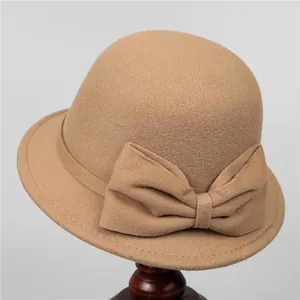 Detail of elegant camel wool cloche hat featuring a decorative side bow and refined stitching