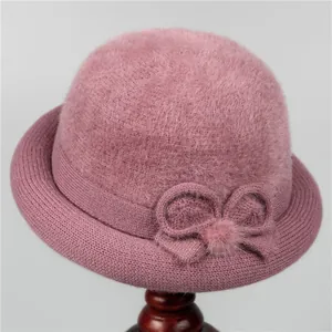 Detail of warm pink winter hat with plush faux fur top and knitted flower accent