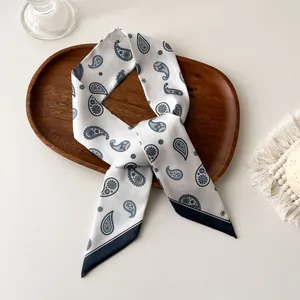 Détail d'un foulard en soie avec motif paisley élégant et bordure bleue marine chic