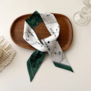 Détail d'un foulard en soie avec imprimé floral vert foncé et texte The Best One Is Me
