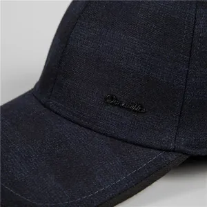 Détail d'une casquette d'hiver bleu marine avec logo métallique et texture en sergé