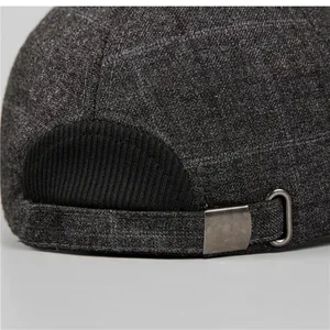 Dettaglio della fibbia in metallo e della trama in tweed grigio sul berretto invernale