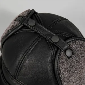 Detail of winter trapper hat showing black leather texture and thick fleece lining