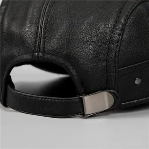 Detail of black leather winter hat featuring an adjustable metal buckle and stitching