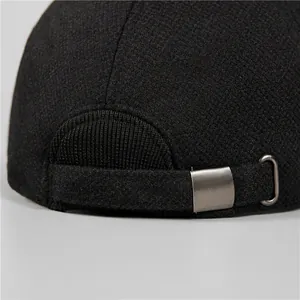 Close-up of black baseball cap with brushed metal buckle and textured fabric