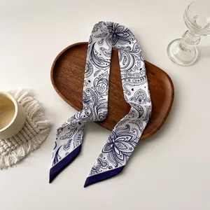 Twilly en soie style français motif paisley bleu et blanc sur un plateau décoratif