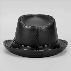 Detail shot of black leather fedora hat featuring classic stitching and smooth texture