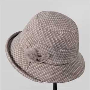 Dettaglio cappello a secchiello in tweed con fiocco decorativo e pompon per donne
