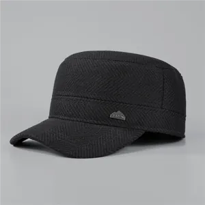 Detail of black herringbone flat top hat with a mountain-shaped metallic logo badge