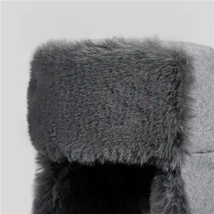 Close-up of grey winter trapper hat showing thick faux fur texture and warm wool fabric