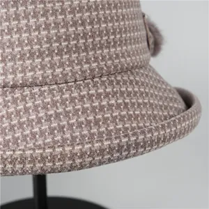 Dettaglio cappello pescatore in lana kaki con trama a maglia e pompon di peluche
