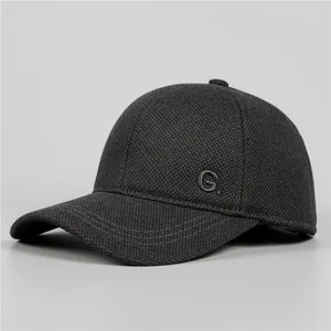Detailed view of grey winter baseball cap with textured fabric and metallic G logo