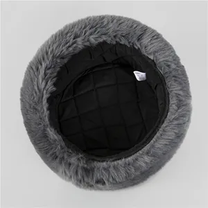 Detail of gray winter faux fur hat featuring soft black quilted lining and laundry tag