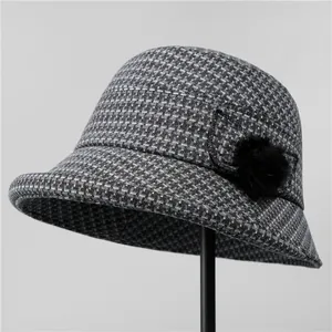 Dettaglio cappello alla pescatora in tweed grigio per anziane con pompon nero decorativo