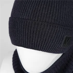 Close-up of navy blue ribbed knit beanie with leather V logo tag and warm fleece lining