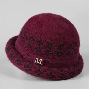 Close-up of wine red knit bucket hat featuring black diamond pattern and crystal M buckle
