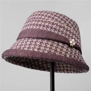 Detail of purple houndstooth wool hat with elegant pearl and rhinestone brooch flower