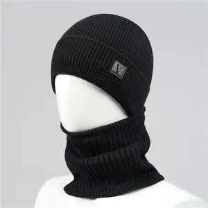 Detail of black ribbed knit beanie and neck warmer set with leather logo patch on a model