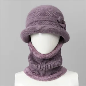 Detail of purple knitted winter hat and neck warmer set with faux fur trim and flower deco