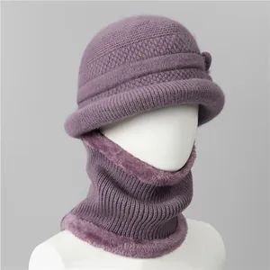 Detail of purple knitted winter hat and scarf set with thick faux fur lining and bow