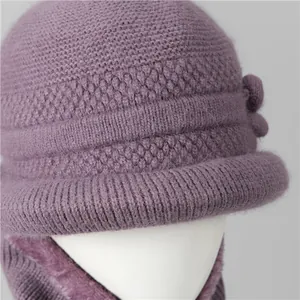 Detail of purple winter knit hat with fleece lining and decorative flower for elderly women