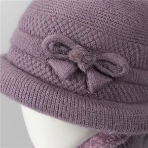Winter knitted purple wool hat for elderly women with bow detail and soft fur ball