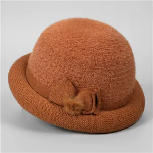 Detail view of caramel winter hat with plush crown, knit brim, and bow decoration
