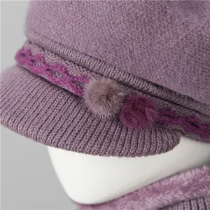 Detalle de gorro de punto morado para mujeres mayores con texturas suaves y pompones
