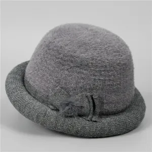 Detail of grey knitted cloche hat featuring plush texture and elegant bow accent
