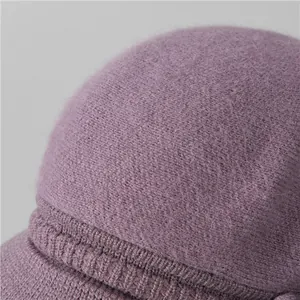 Vista macro del gorro de punto morado que muestra la textura suave y detalles de felpa
