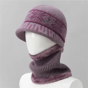 Detalle de conjunto de gorro y bufanda de punto violeta con motivos de copos de nieve