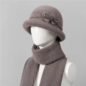 Detailed close-up of knit winter hat and scarf set with elegant bow and faux fur pom-pom