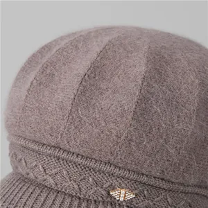 Detalle del gorro de punto de pelo de conejo con hebilla de abeja de perlas y textura suave