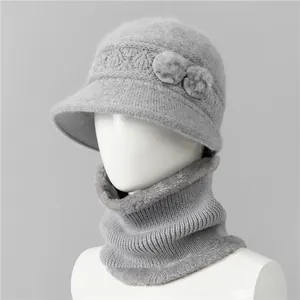 Detalle de conjunto de gorro y bufanda de punto gris con flores de piel en un maniquí