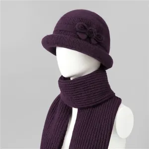 Detailed view of dark purple rabbit fur knit hat with bow ornament and matching scarf