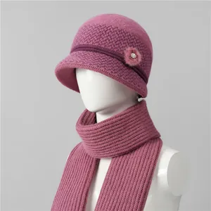 Detail of pink knitted winter hat and scarf set with faux fur flower and pearls