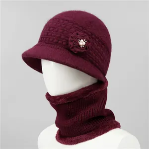 Detalle de gorro de punto rojo oscuro con flor de perlas y calentador de cuello
