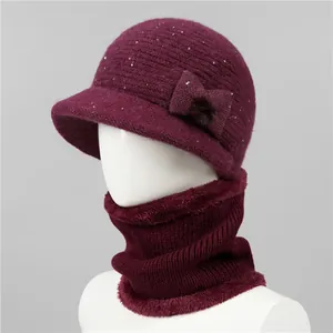 Detalle de conjunto de gorro y bufanda de punto granate con lentejuelas y un lazo
