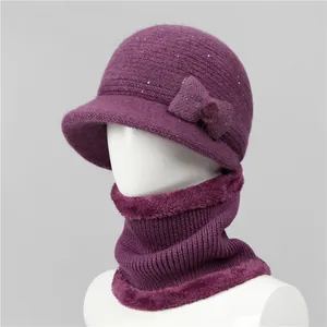 Detalle de conjunto de gorro de punto y bufanda morada con lazo y borde de piel
