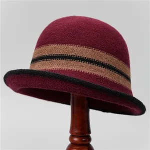 Close-up of wine red knitted bucket hat with vintage contrast stripe and wool texture