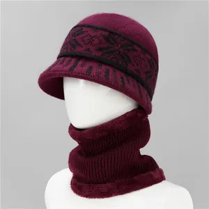 Detalle de gorro y bufanda de punto burdeos con forro polar grueso y diseño de copos de nieve